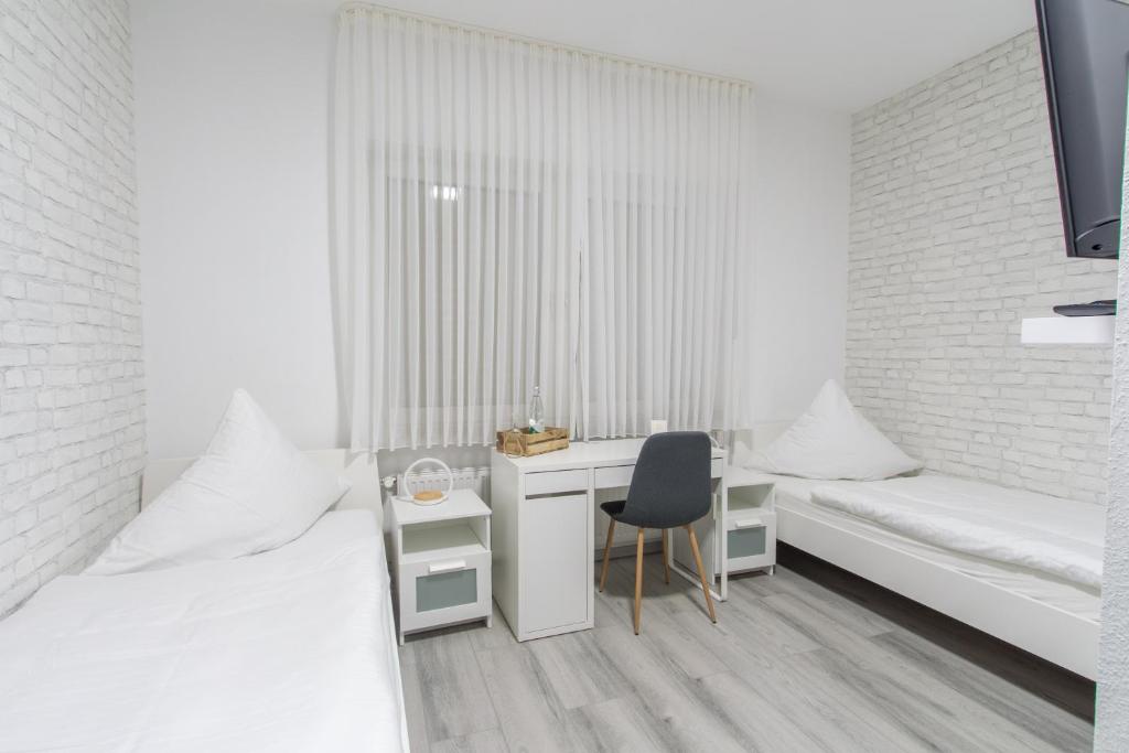 a white room with a desk and a bed at Hotel Billard Center Weywiesen in Bottrop