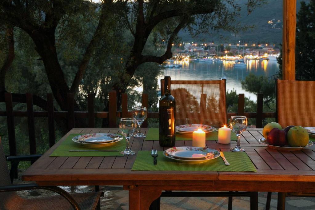 una mesa de madera con una botella de vino y copas en Villa Nefeli en Yenion