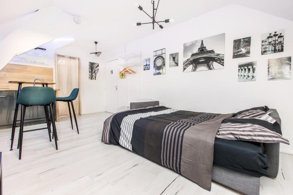 une chambre avec un lit, une table et une chaise dans l'établissement Studio Paris, à Tourcoing