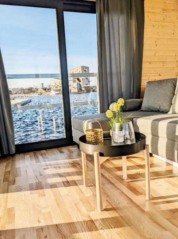 uma sala de estar com um sofá e uma mesa em Schwimmendes Haus Nico auf dem Wasser inkl Boot in Västervik em Västervik