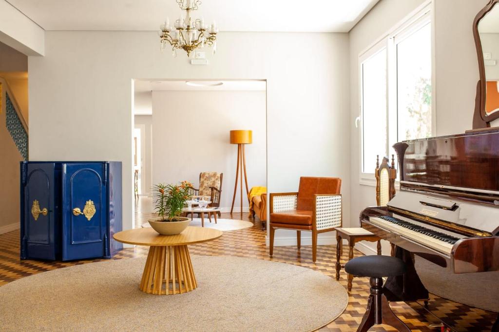 a living room with a piano and a table at Paranaguá Lodge in Paranaguá