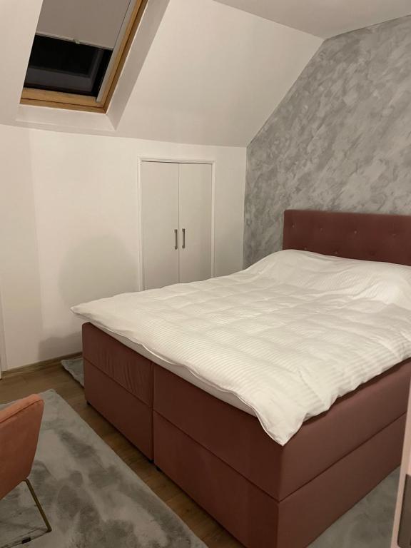 a bedroom with a large bed and a chair at Sofia Loft in Bistriţa
