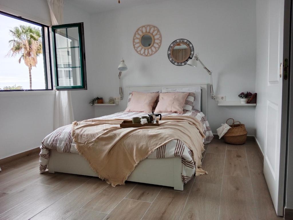 een slaapkamer met een bed en een spiegel aan de muur bij MI ALMA in Puerto del Carmen