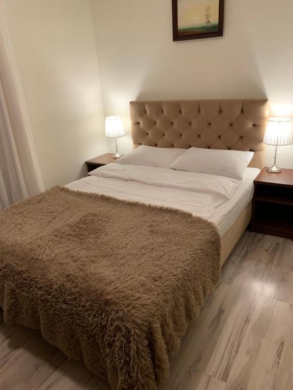 a bedroom with a large bed with a brown blanket at Villa Marina in Dąbki