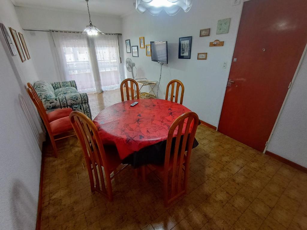 comedor con mesa roja y sillas en EFDEPARTAMENTOS Dos ambientes Plaza Colon en Mar del Plata