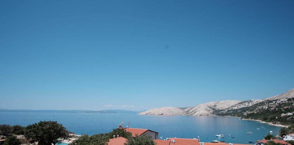 uitzicht op een meer met bergen op de achtergrond bij Eola Leisure Rooms in Stara Baška