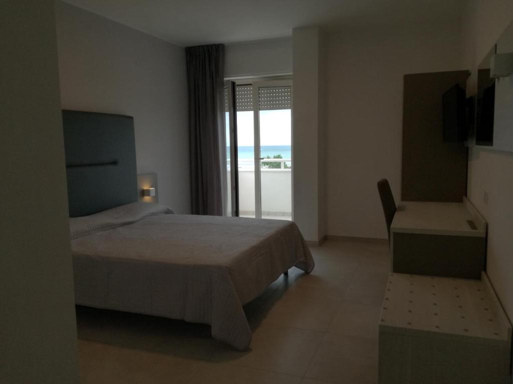 sypialnia z łóżkiem i widokiem na ocean w obiekcie Nuovo HOTEL SETTIBI 20m dalla spiaggia w mieście Giulianova