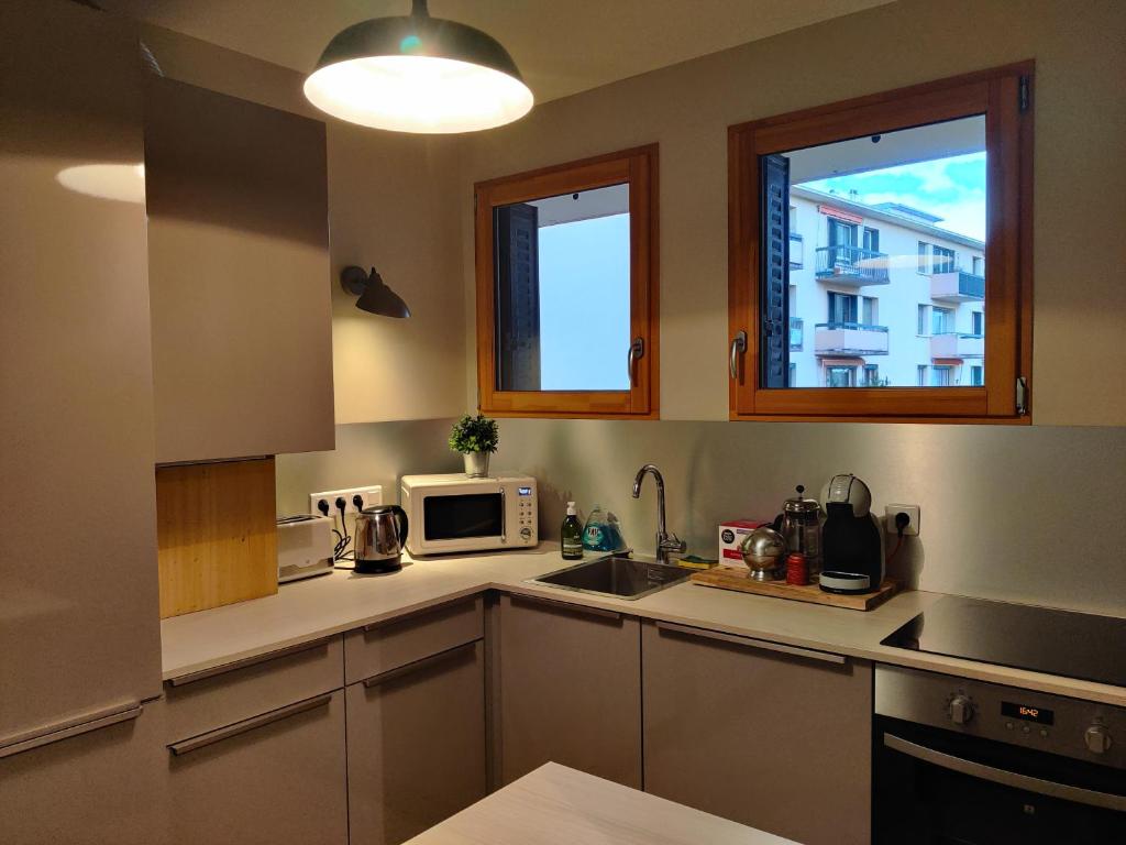 a kitchen with a sink and a microwave at Appartement du parc des thermes in Thonon-les-Bains