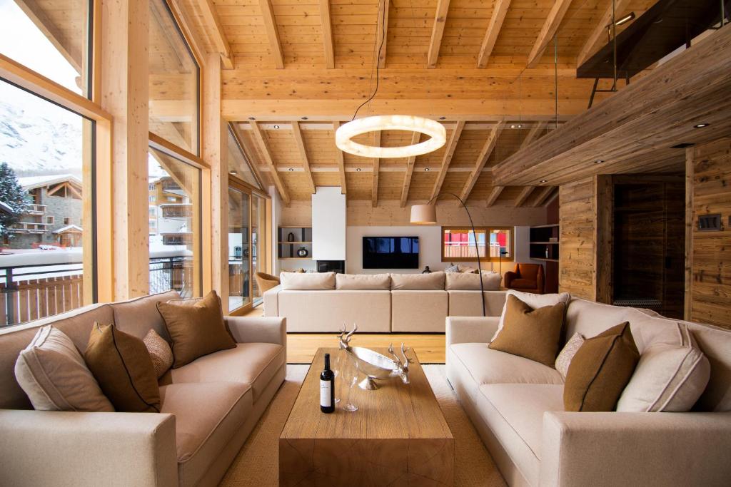 a living room with couches and a table at Berghof Penthouse in Saas-Fee