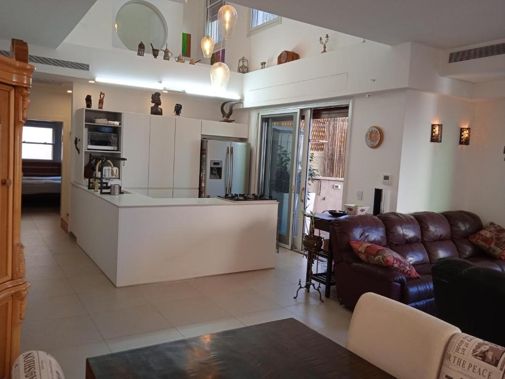 a living room with a couch and a kitchen at Jaffa sea front, luxury Duplex, Port & Old City 2m walk in Tel Aviv