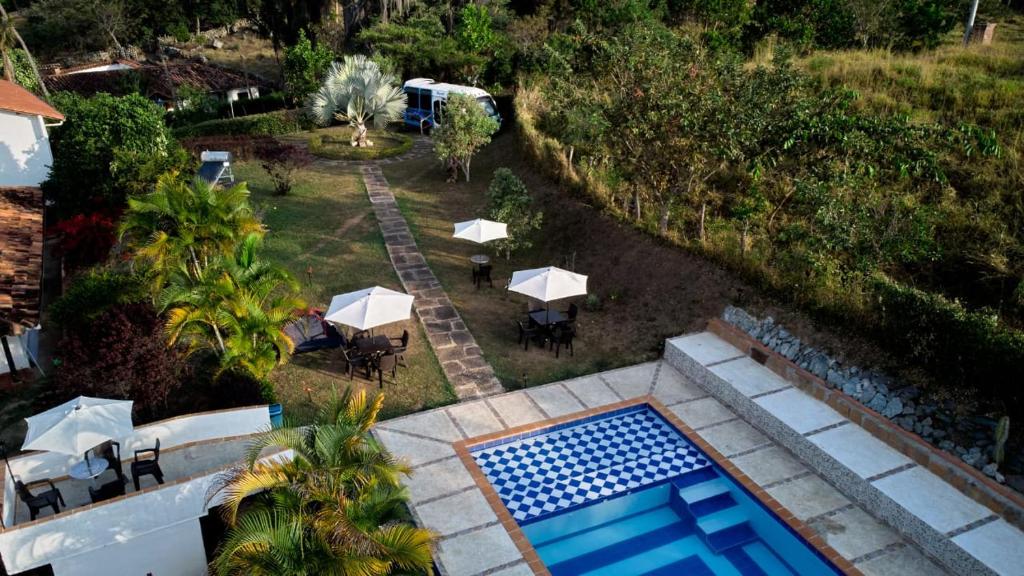 una vista aerea di un cortile con piscina, tavoli e ombrelloni di Villa Maria Casa Campestre a San Gil