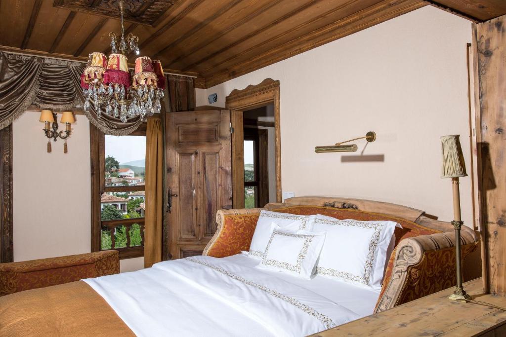 1 dormitorio con cama y lámpara de araña en Terrace Houses Sirince, en Selçuk