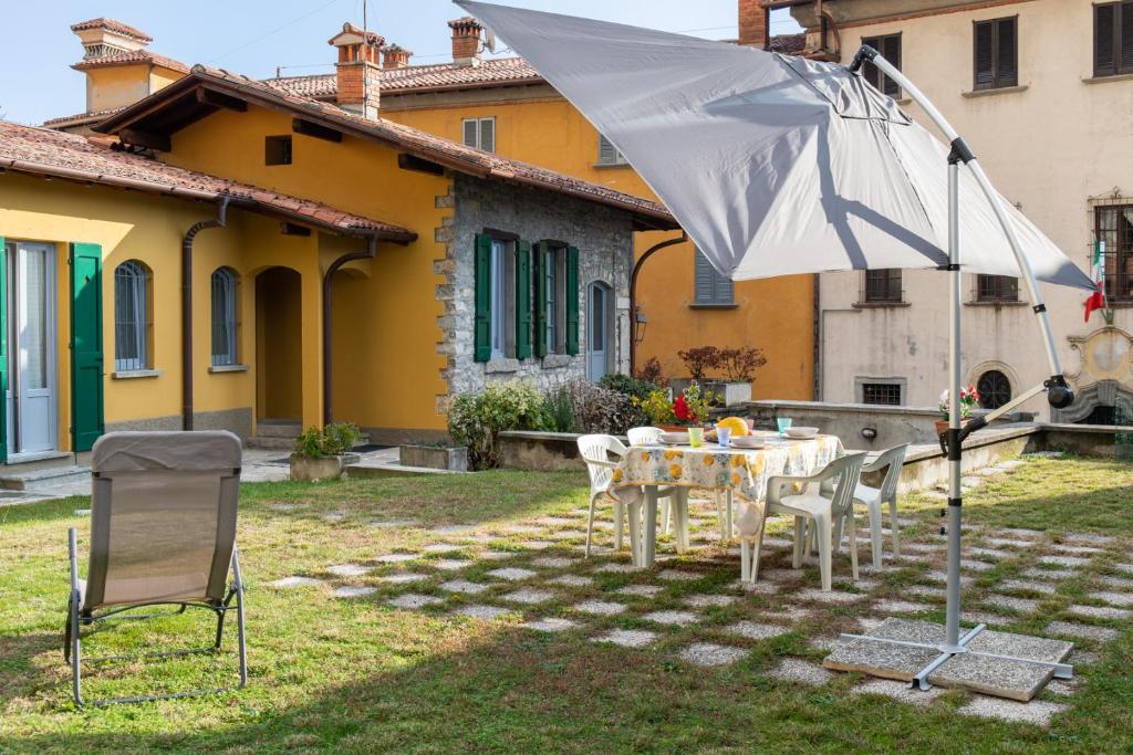 a table and chairs and an umbrella in a yard at La Casetta in Tremezzo