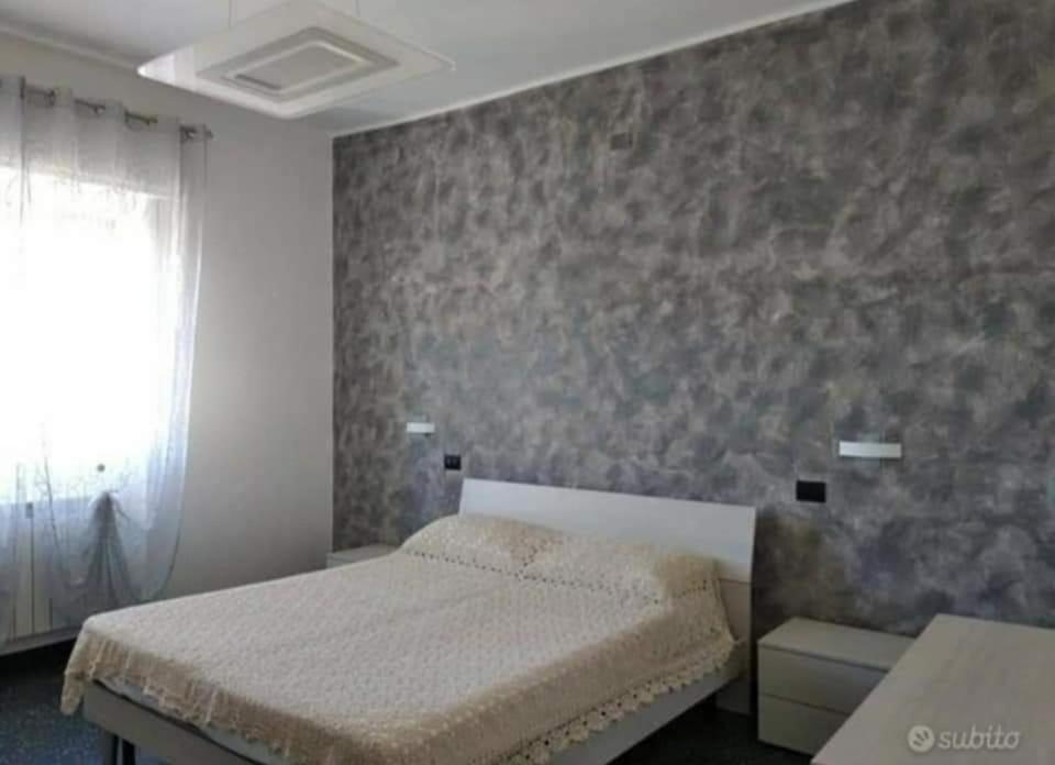 a bedroom with a bed and a stone wall at Ad Un Passo Dal Mare in Savona