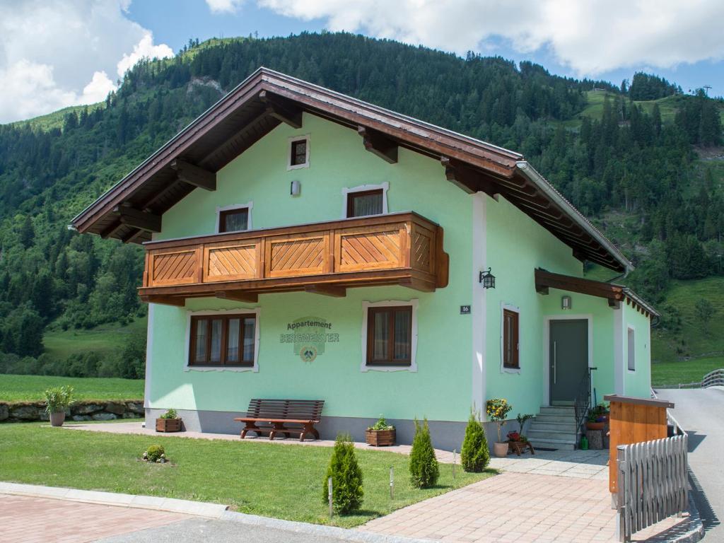 ein Haus mit einem Holzbalkon und einer Bank in der Unterkunft Appartement Bergmeister in Rauris