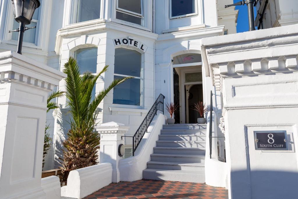 a white house with white stairs and a door at The Halcyon in Eastbourne