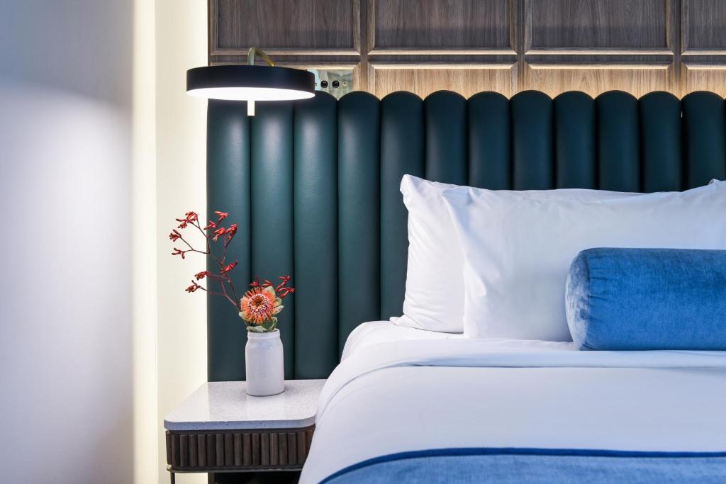 a bedroom with a bed and a green headboard at Powerhouse Hotel Tamworth by Rydges in Tamworth