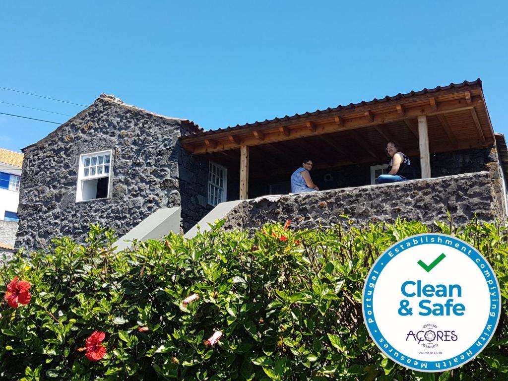Calheta de Nesquim的住宿－Adega da Figueira，两人坐在房子的阳台上