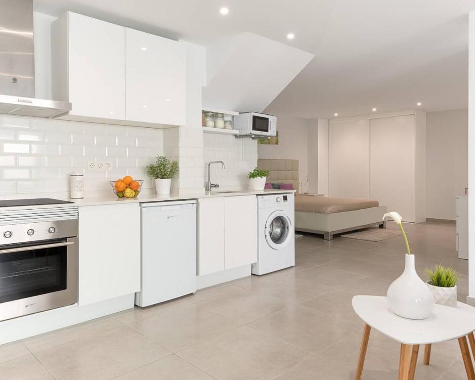 a white kitchen with a sink and a dishwasher at Lily’s Casa in Benijófar