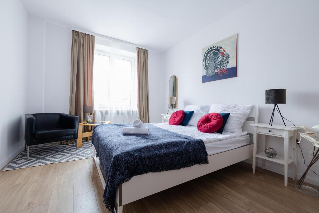 - une chambre avec un lit doté d'une couverture bleue et d'une chaise dans l'établissement Pod Skrzydłami - centrum - 24h, à Częstochowa