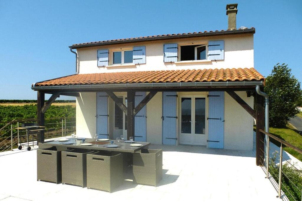 Cette maison dispose d'une grande terrasse avec un toit. dans l'établissement Holiday Home in Chenac with Stunning Terrace Views, à Chenac Saint Seurin D'uzet