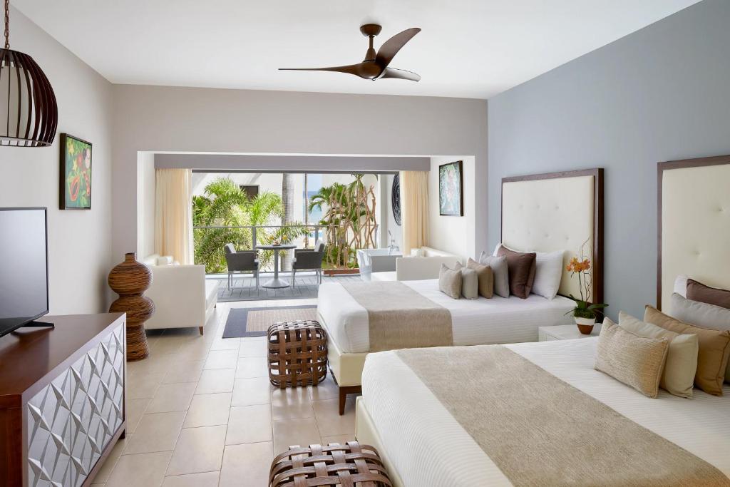 a bedroom with two beds and a living room at Zoetry Montego Bay in Montego Bay