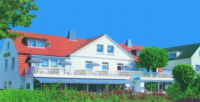 una gran casa blanca con techo rojo en Hotel Seelust, en Hohwacht