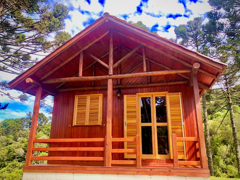 a small wooden cabin with a large window at Recanto Baú - Chalé in Bom Jardim da Serra