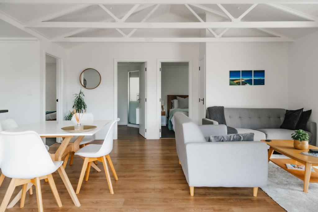 uma sala de estar com um sofá e uma mesa em Te Puna Cottage Gardens B&B em Tauranga