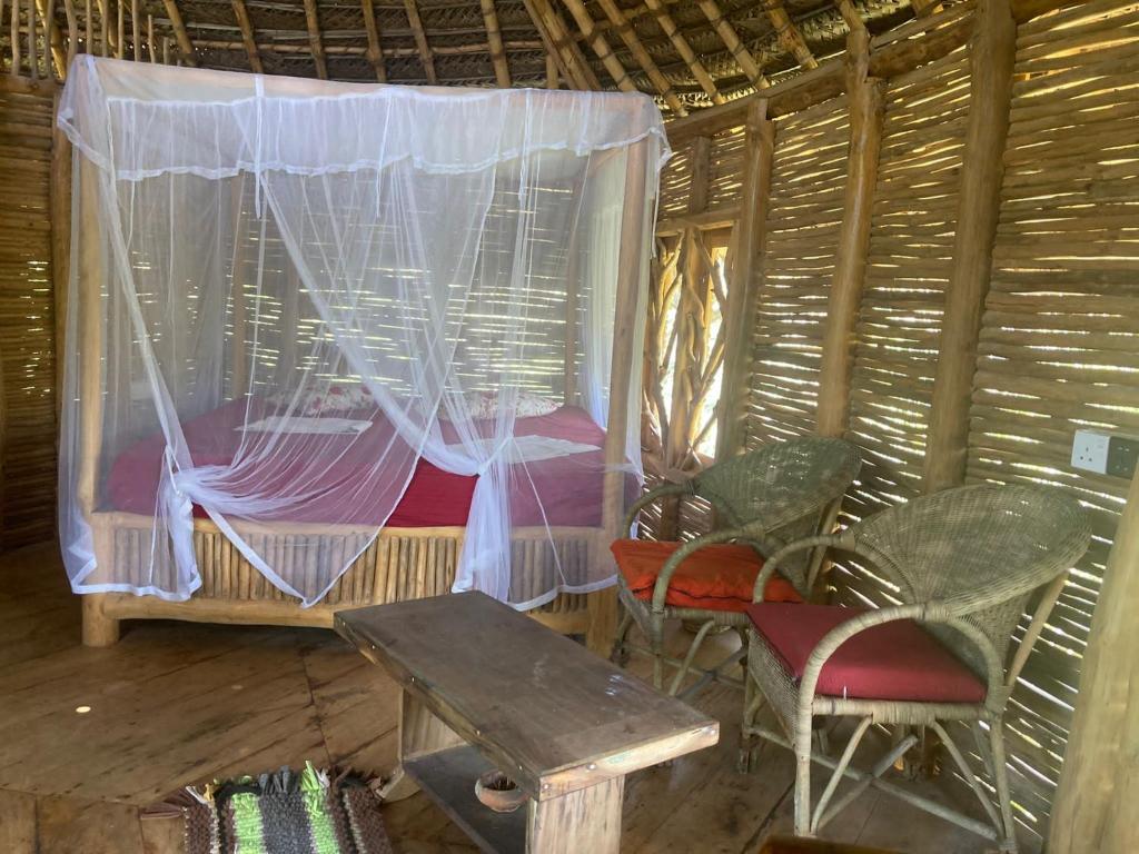 una stanza con un letto, un tavolo e delle sedie di The Alpha Monkey hotel & Tree house a Tangalle