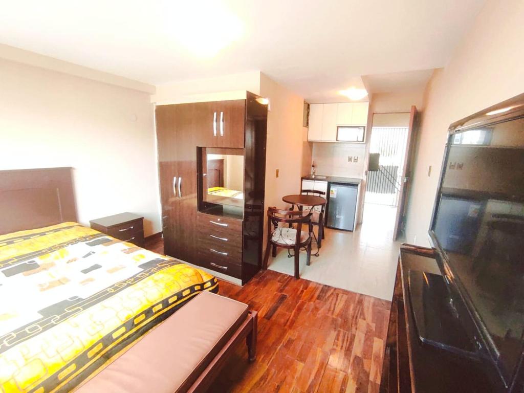 een woonkamer met een bed en een keuken bij Zona Sur - Lindo Monoambiente en la Meseta de Achumani - URBEANDINA in La Paz