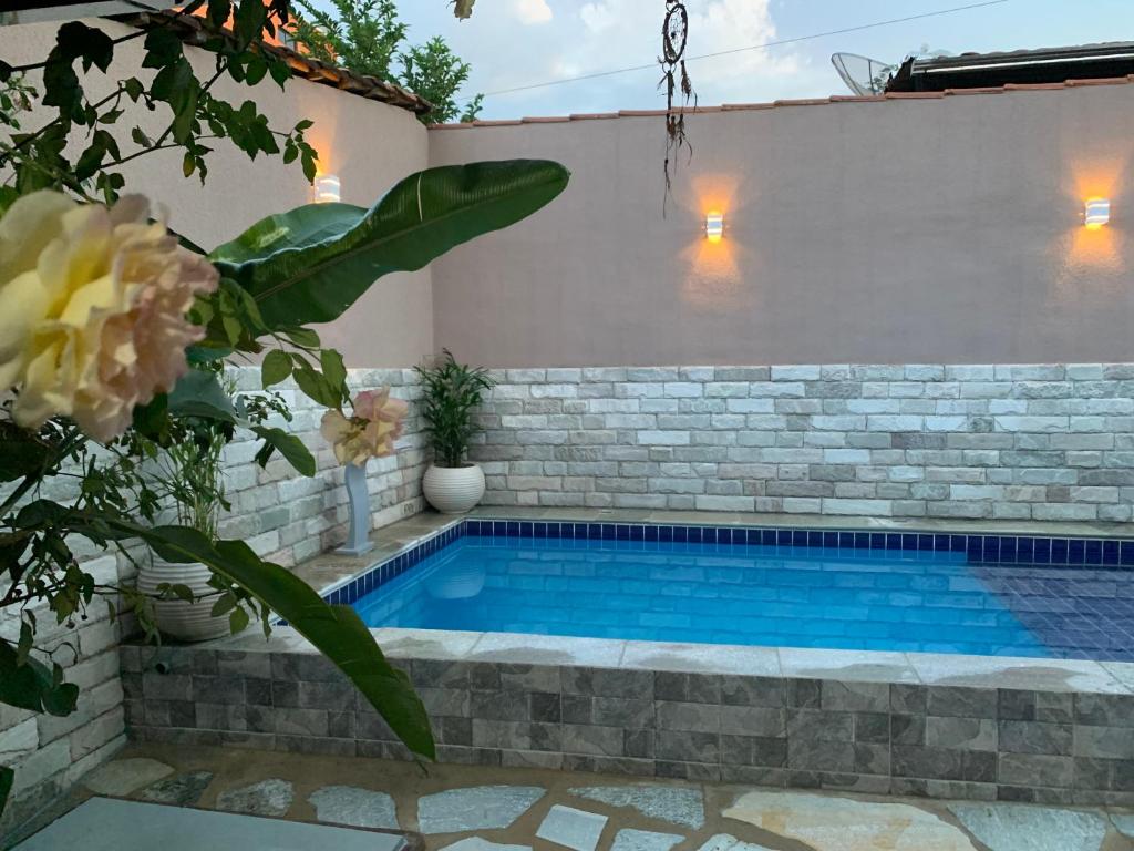 una piscina en un patio trasero con una pared de ladrillo en Casa dyliau, en Pirenópolis