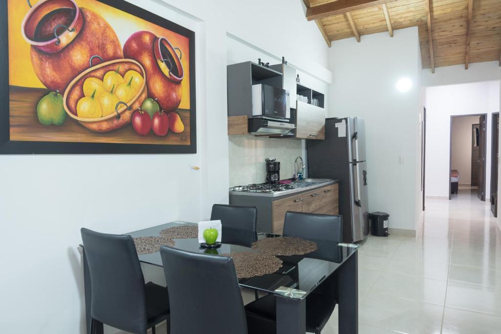 uma cozinha e sala de jantar com uma pintura de frutas na parede em El EmAnJe 1 em Jardín