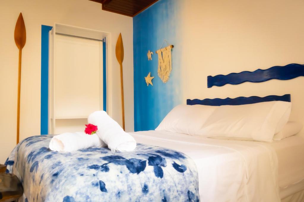 um quarto azul e branco com uma cama com toalhas em Raio de Sol pousada & camping em Abraão
