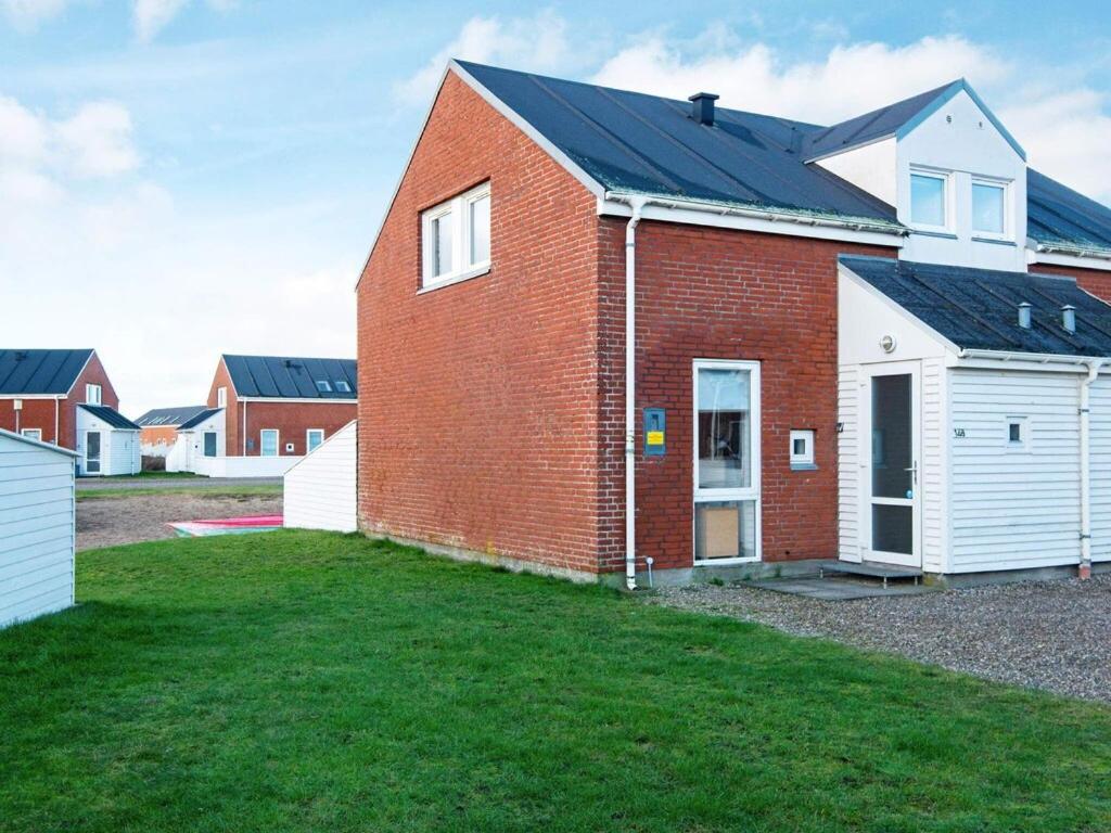 una casa de ladrillo con techo negro y patio en 6 person holiday home in R m en Rømø Kirkeby