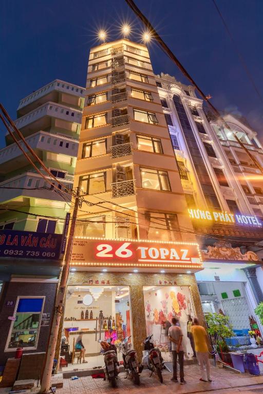 a tall building with people standing in front of it at 26 Topaz Hotel in Vung Tau
