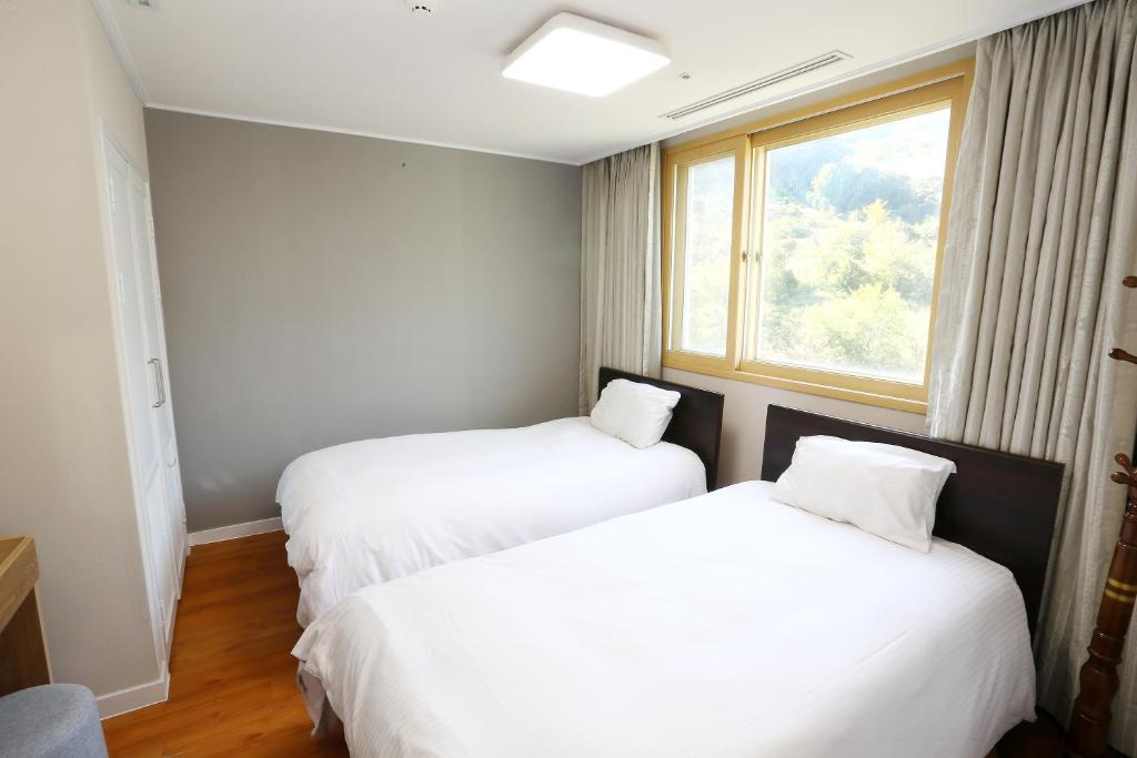 Postel nebo postele na pokoji v ubytování The K Jirisan Family Hotel