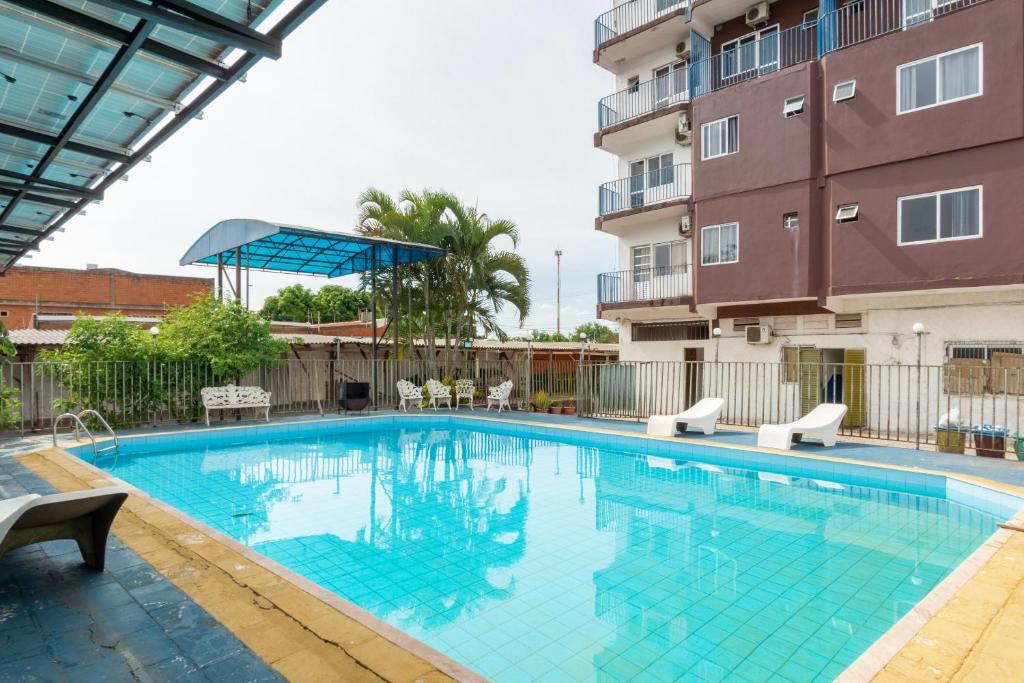 a swimming pool in front of a building at OYO Nacional Palace Hotel, Foz do Iguaçu in Foz do Iguaçu