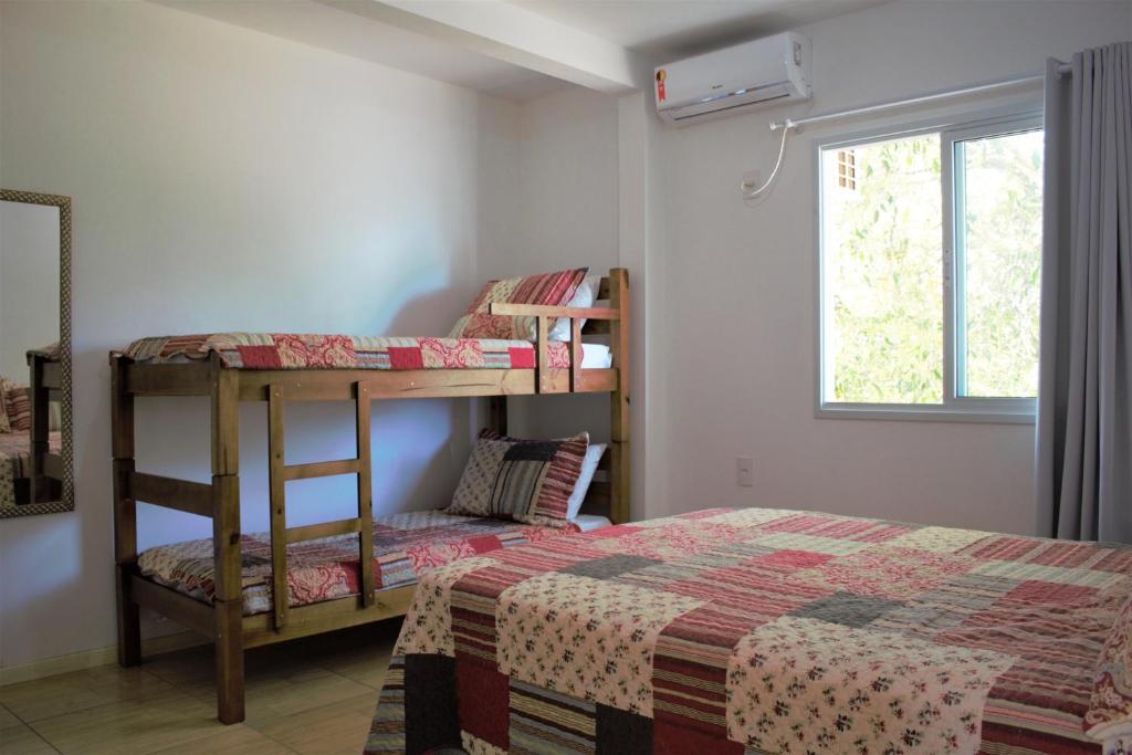 1 dormitorio con 2 literas y 1 cama en Apartamento Sunset, à 80 metros da praia, en Palhoça