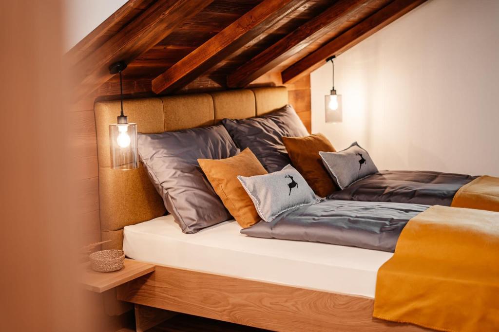 een slaapkamer met een bed met kussens erop bij Bergmoment Apartments in Obertraun