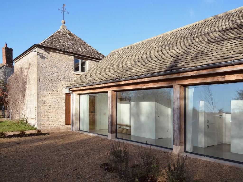 an extension to a house with large sliding glass doors at High Cogges Farm Holiday Cottages - The Cart Shed in Witney
