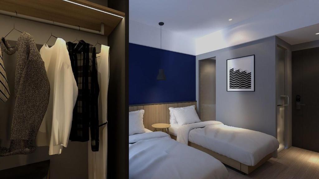 a hotel room with two beds and a closet at LeGreen Suite Sudirman in Jakarta