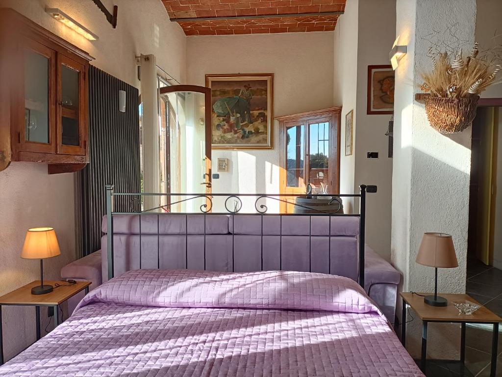 sypialnia z fioletowym łóżkiem z 2 lampami w obiekcie La Limonaia Country House w mieście Monteriggioni