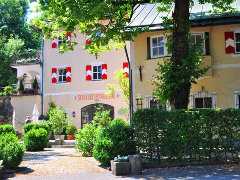 ein Gebäude mit roten und weißen Flaggen darauf in der Unterkunft Ferienwohnungen Schlosseinkehr in Aschau im Chiemgau