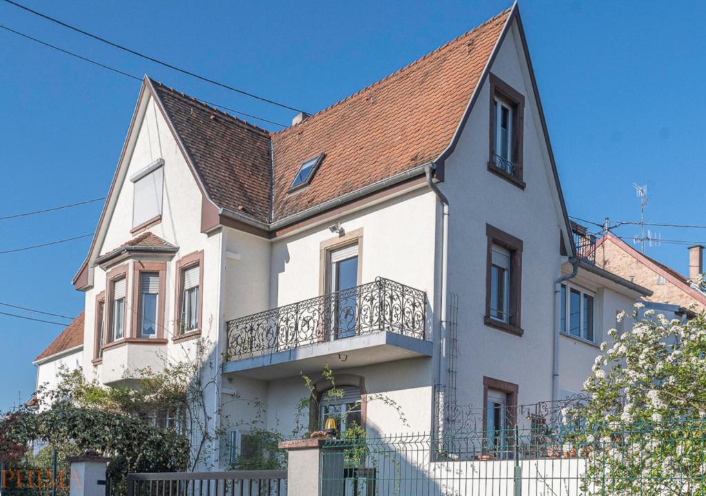 uma casa branca com um telhado castanho em au-dessus du jardin appartement climatisé em Eckbolsheim