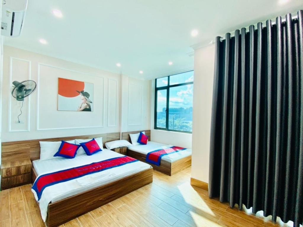 Việt Yên的住宿－Ngoc Khanh Hotel，一间卧室设有两张床和窗户。