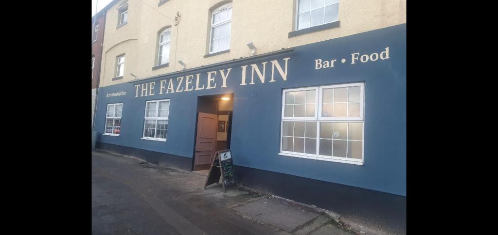 un edificio azul con la legendaria comida de bar de la posada en The Fazeley Inn en Fazeley