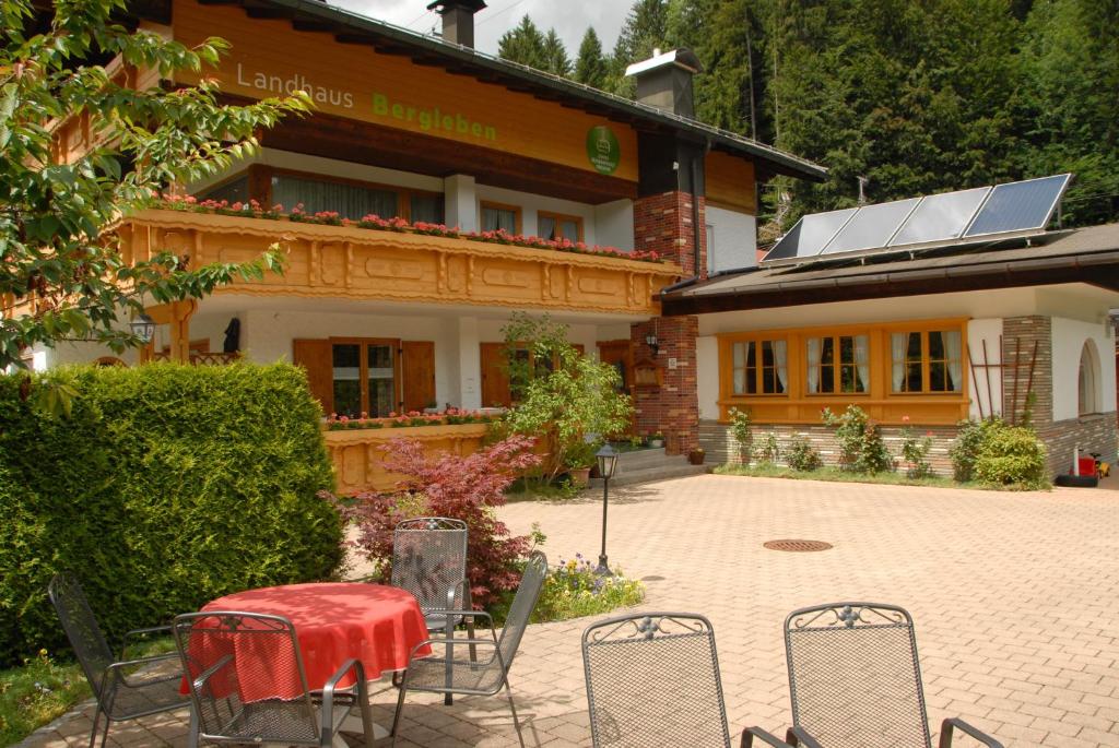 un groupe de chaises et une table devant un bâtiment dans l'établissement Landhaus Bergleben, à Oberstdorf