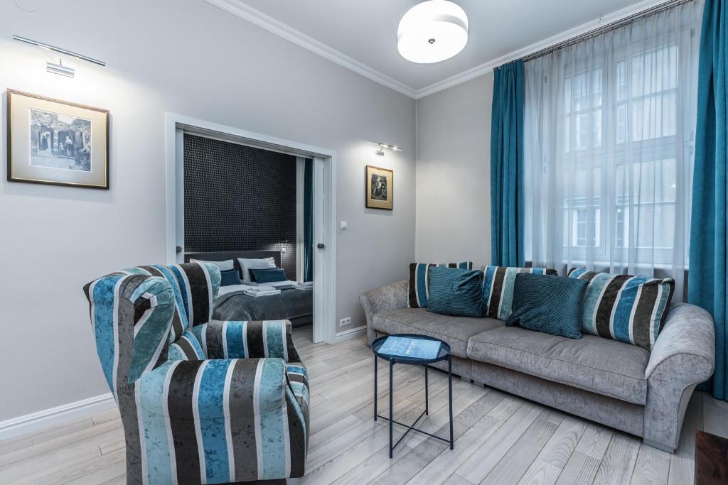 een woonkamer met een bank en twee stoelen bij Rent like home - Ślusarska 13 in Poznań