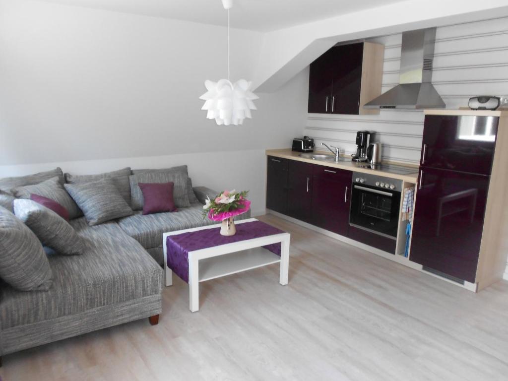 ein Wohnzimmer mit einem Sofa und einem Tisch in der Unterkunft Ferienwohnungen Haus Glückauf in Ostseebad Kölpinsee